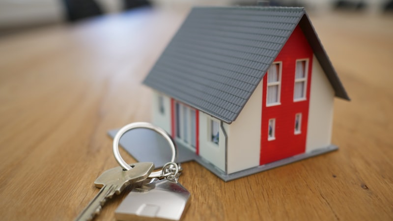 House keys and model home representing remodel investment costs